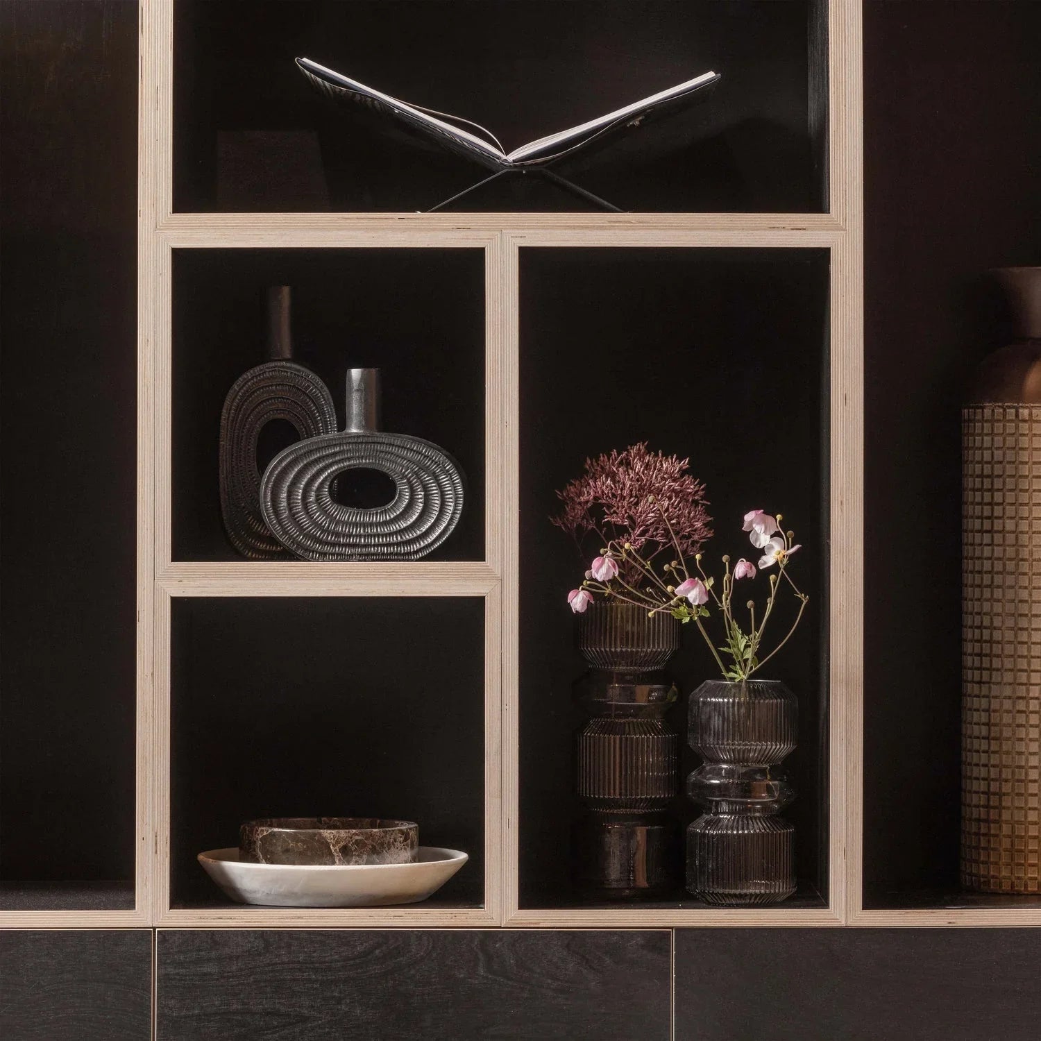 Modern shelving with decorative vases, ceramic bowl, and fresh flowers in glass jars