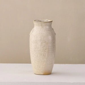 Minimalist beige ceramic vase with textured matte finish on a light surface