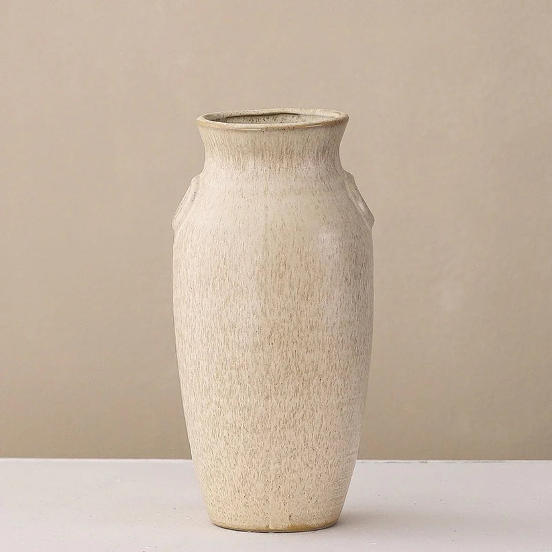 Minimalist beige ceramic vase with textured finish on light background