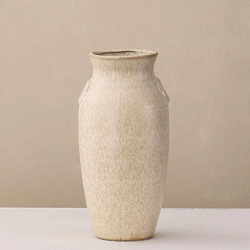 Minimalist beige ceramic vase with textured finish on light background
