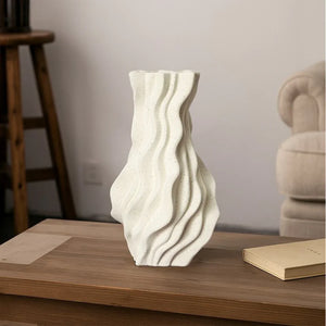 Modern wavy white ceramic vase on wooden table in minimalist living room decor