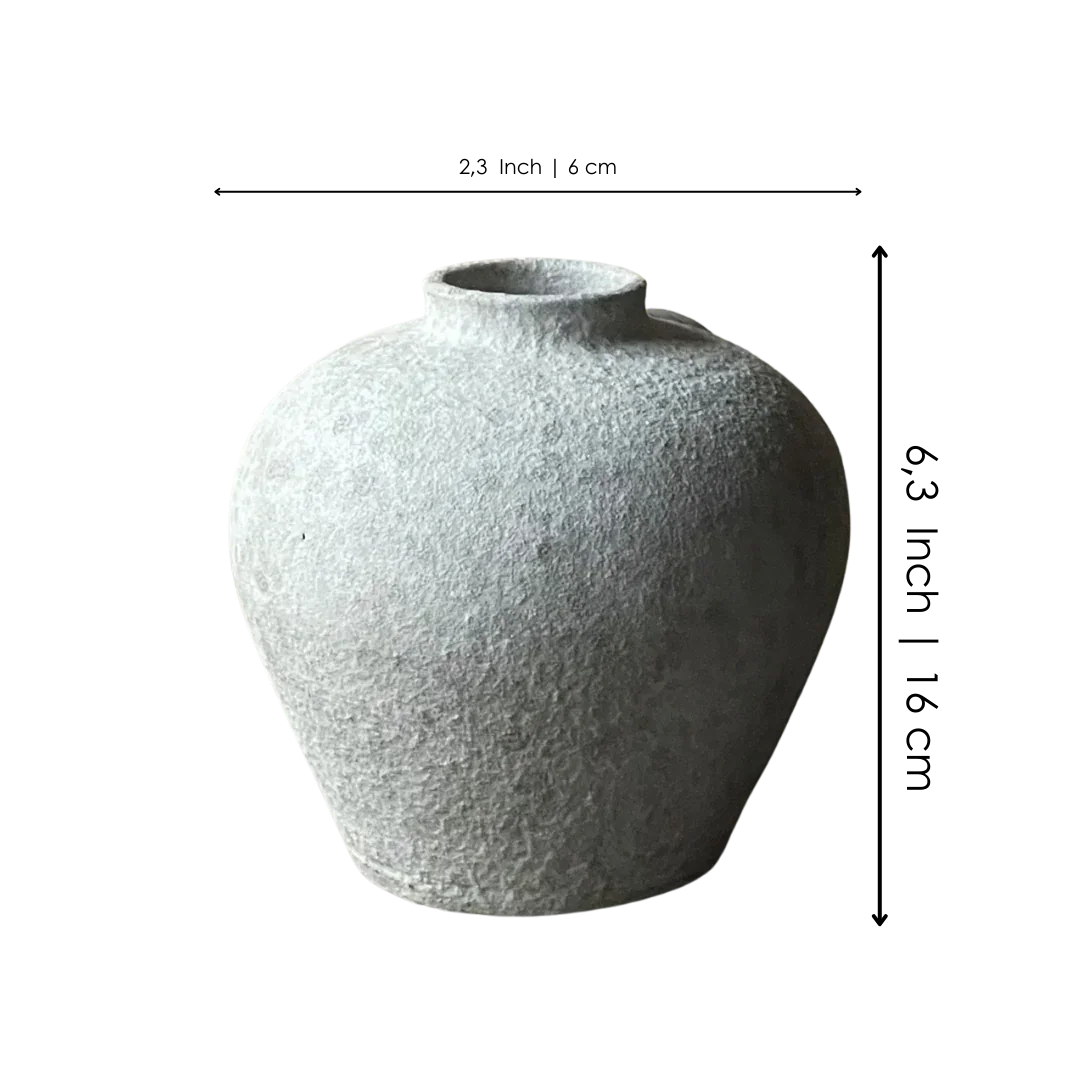 Textured round gray ceramic vase with a narrow opening, minimalist home decor.