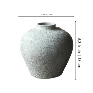 Textured round gray ceramic vase with a narrow opening, minimalist home decor.