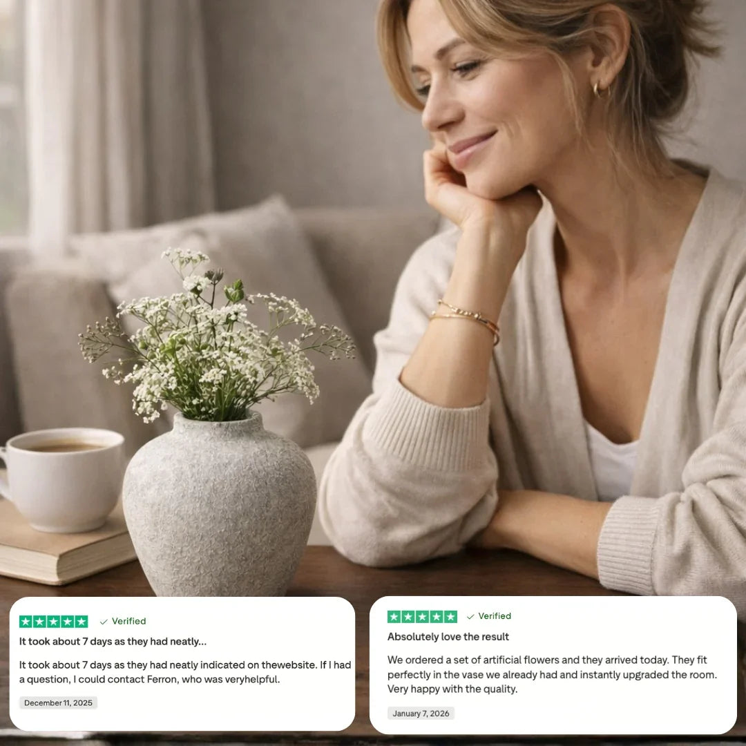 Woman enjoying coffee beside white artificial flowers in vase, customer reviews visible.