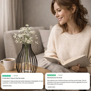 Woman reading on sofa next to artificial flowers in decorative vase, coffee cup, and customer reviews.